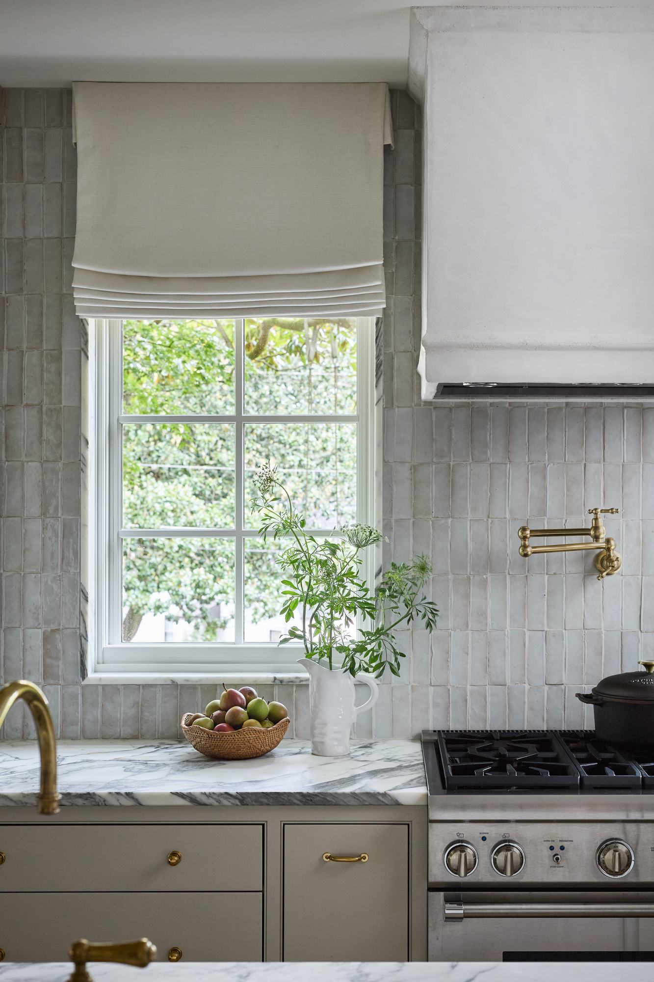 Kitchen window with handmade tile backsplash and a bowl of pears
