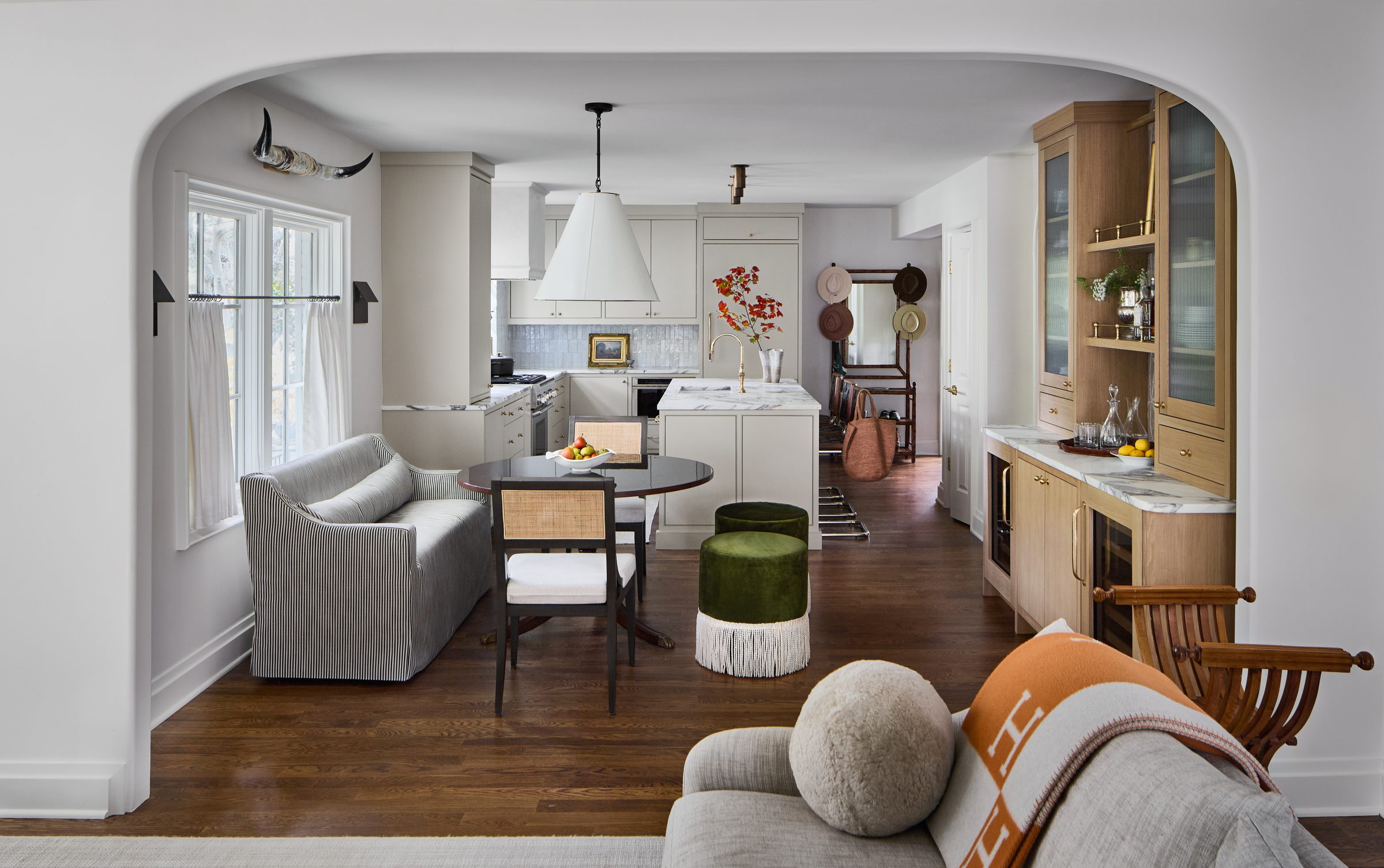 Open kitchen, dining, and bar area with arched doorway