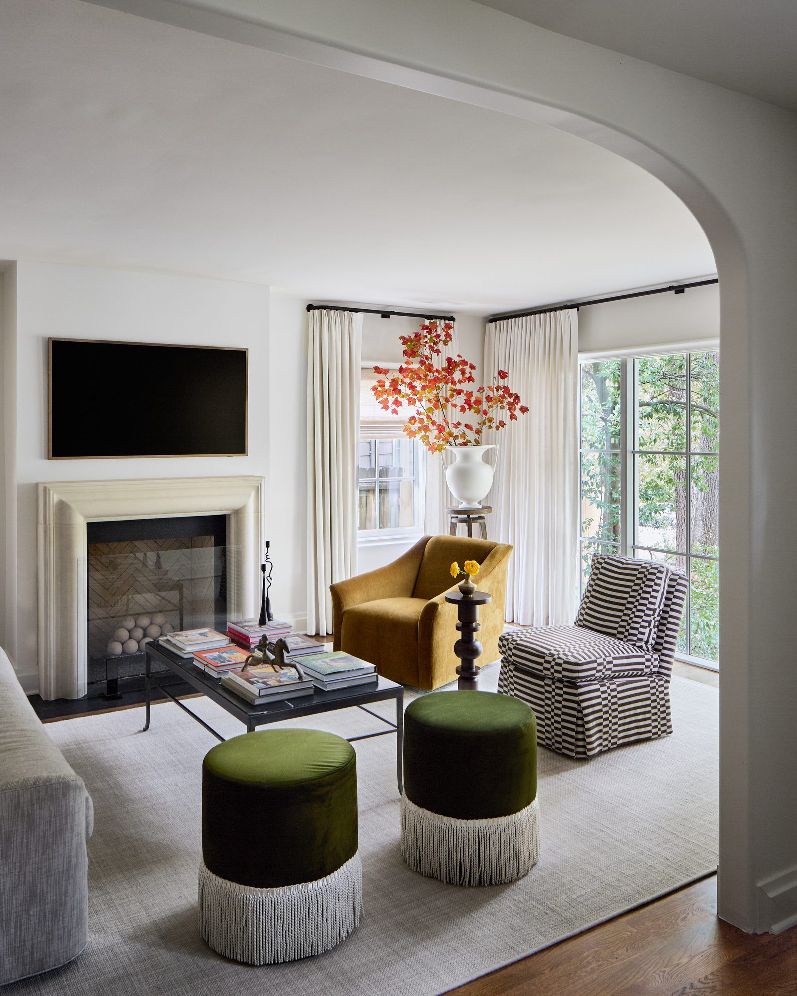 Living room with mustard velvet swivel chair and stone fireplace