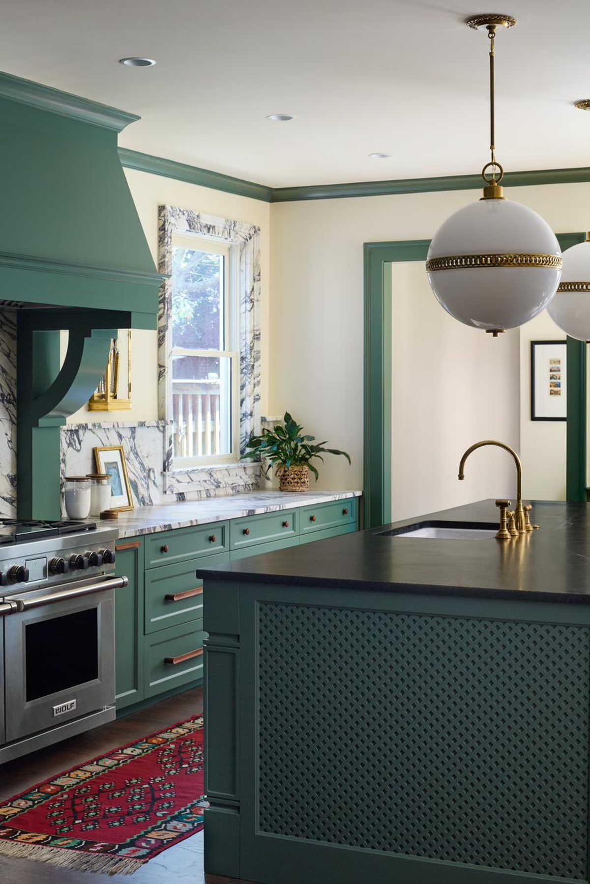 Green built-in pantry cabinetry with bar nook and brass hardware